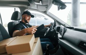 delivery driver checking his phone on route with packages