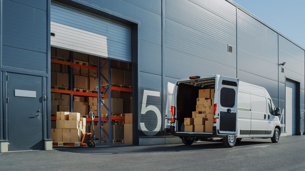 Why Do Amazon Delivery Drivers See Higher Rates of Injuries? white van with packages in the back with the doors open outside of a warehouse
