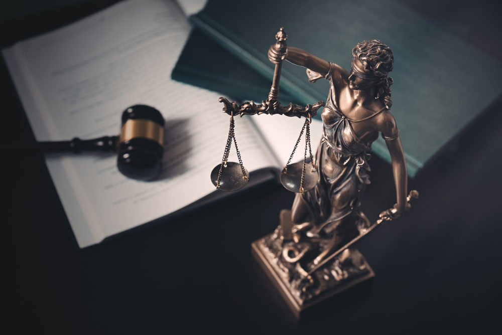 desk with gavel books and lady justice statue