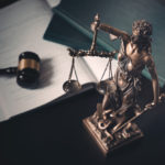 desk with gavel books and lady justice statue