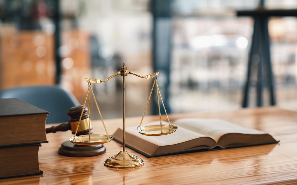 attorneys desk with an open law book a gavel and scales