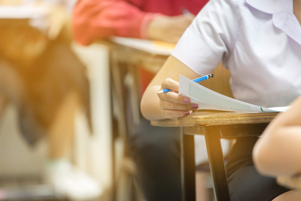 students sitting in a row of chairs in classroom.