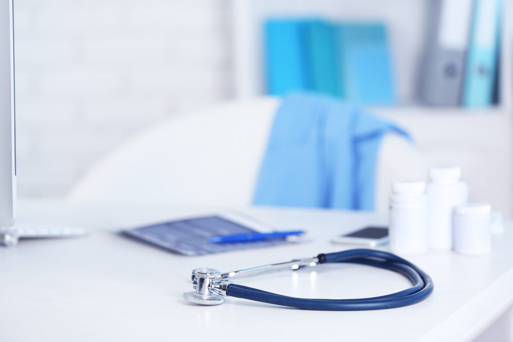 doctors workplace with stethoscope and pill bottles