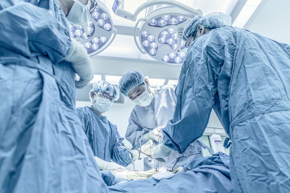 What Common Surgeries Carry the Highest Risks of Harm? Surgeons performing total knee replacement surgery in operating room