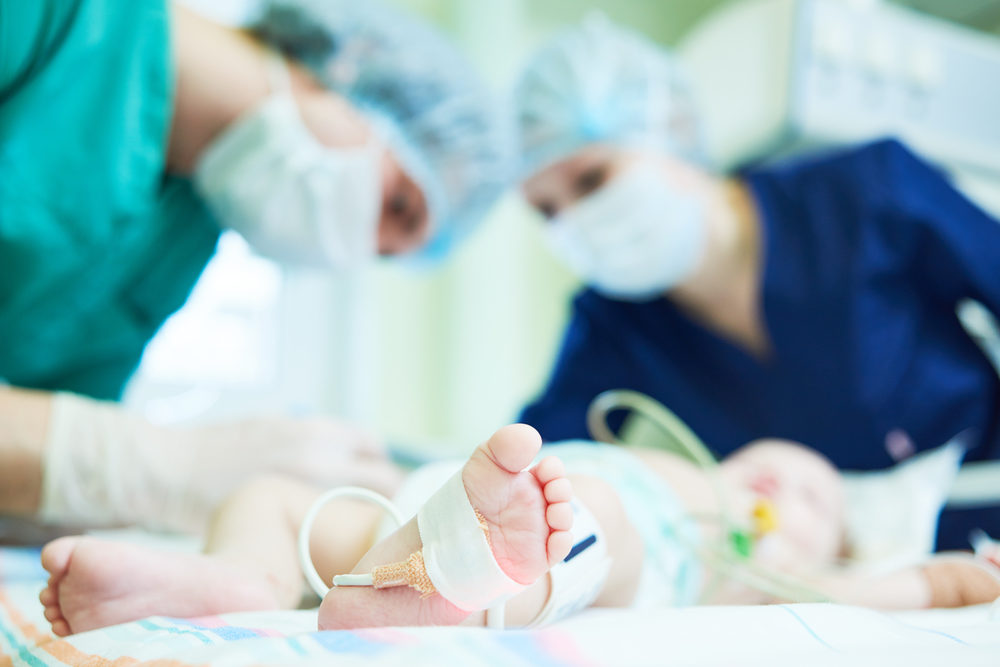 Doctor's team doing neonatal resuscitation therapy on newborn baby.