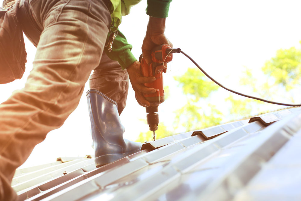 Personal Injury from Construction – What to Know in Texas worker drilling down roofing tiles