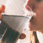 woman is drinking dirty water from the glass cup