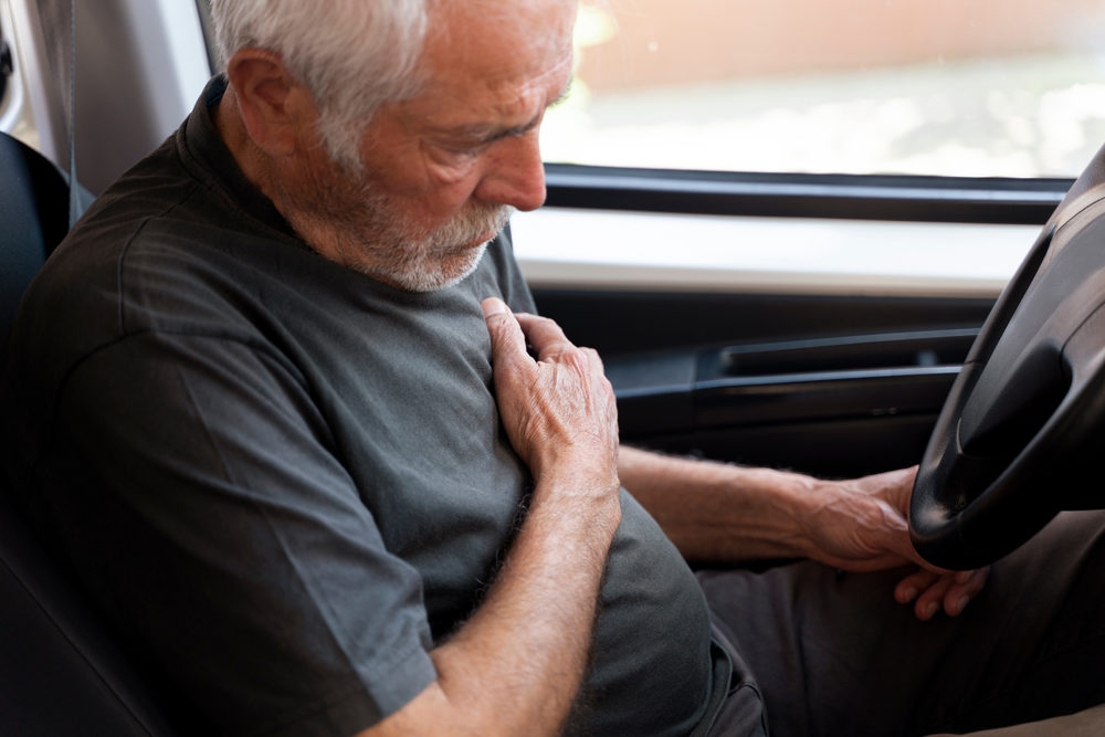 Senior man with Chest Pains Driving a Car.