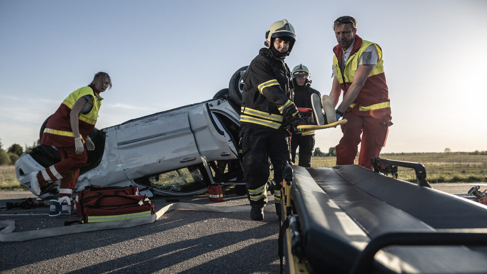 Madera Rollover Collision on Avenue 17 Injures Two emergency responders at an overturned vehicle accident scene transporting an injured person on a stretcher