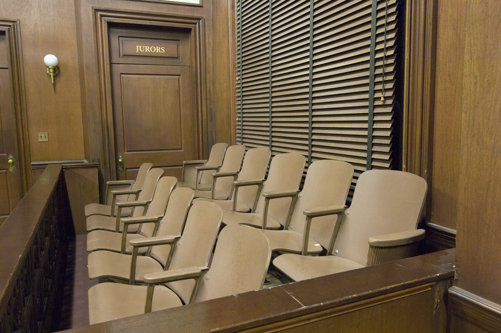 an empty jury box in a courtroom with wood walls and accents