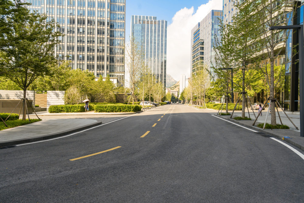 An empty roadway leading to a downtown urban area