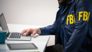FBI agent in uniform in office using laptop