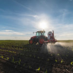 Tractor spray fertilize field with insecticide herbicide chemicals in agriculture field