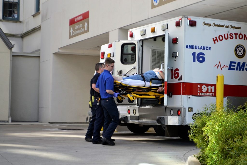 A patient is unloaded from an ambulance at a hospital emergency department