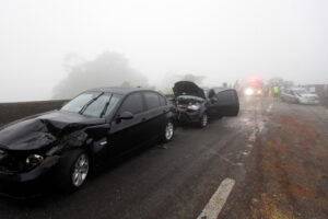 Car collision in a dense fog on roadway