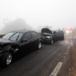 Car collision in a dense fog on roadway
