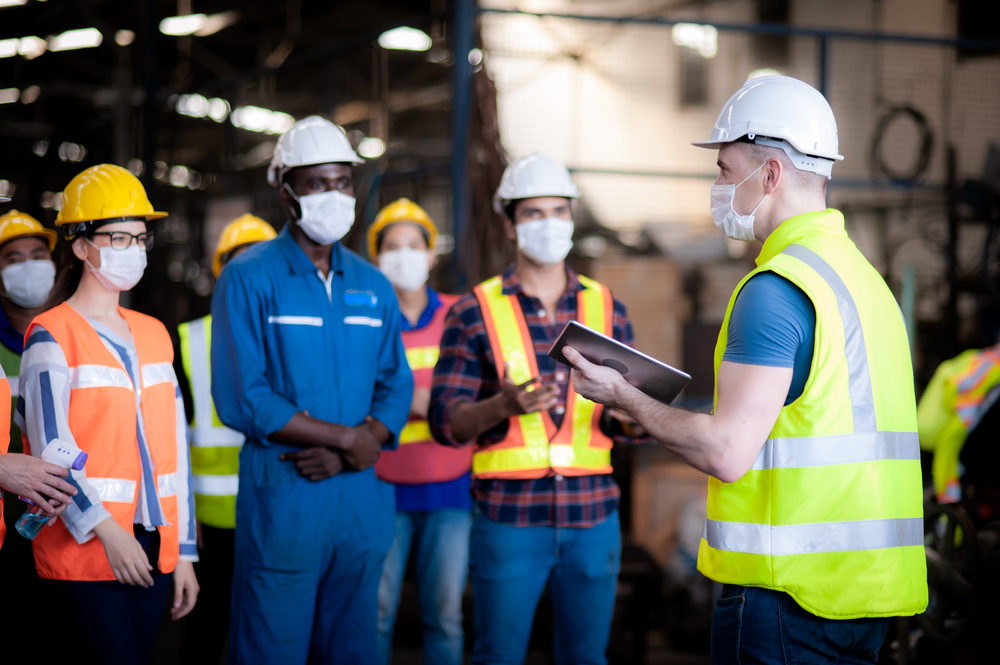 Foreman instructing technicians in a factory at start of shift