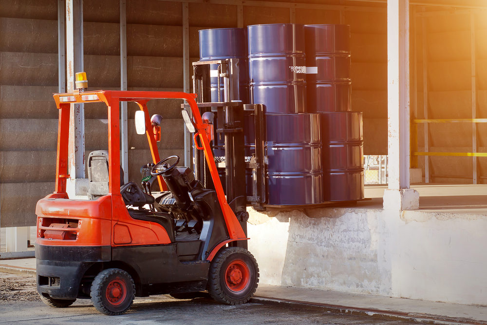 forklift carrying barrels onto loading dock