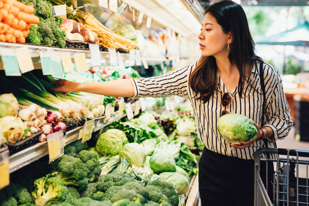 A woman inspecting the fresh produce at a supermarket