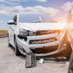 view of front of a white car damaged by an auto accident