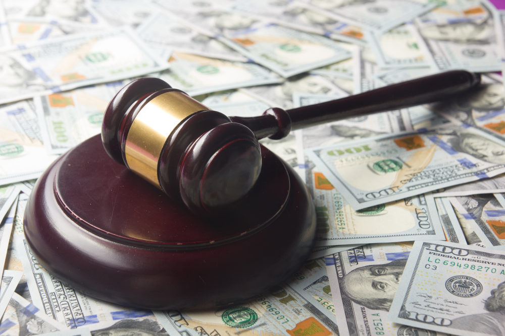 gavel on a table covered in $100 U.S. bills