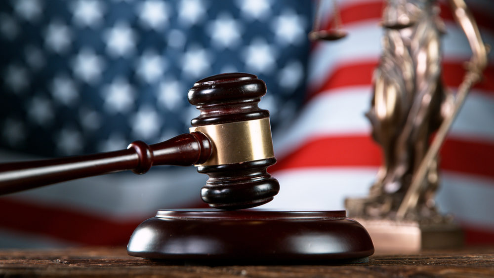 gavel and scales with a united states flag behind 