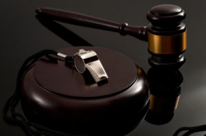  metal whistle and wooden judge gavel on dark background