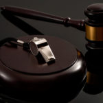 metal whistle and wooden judge gavel on dark background