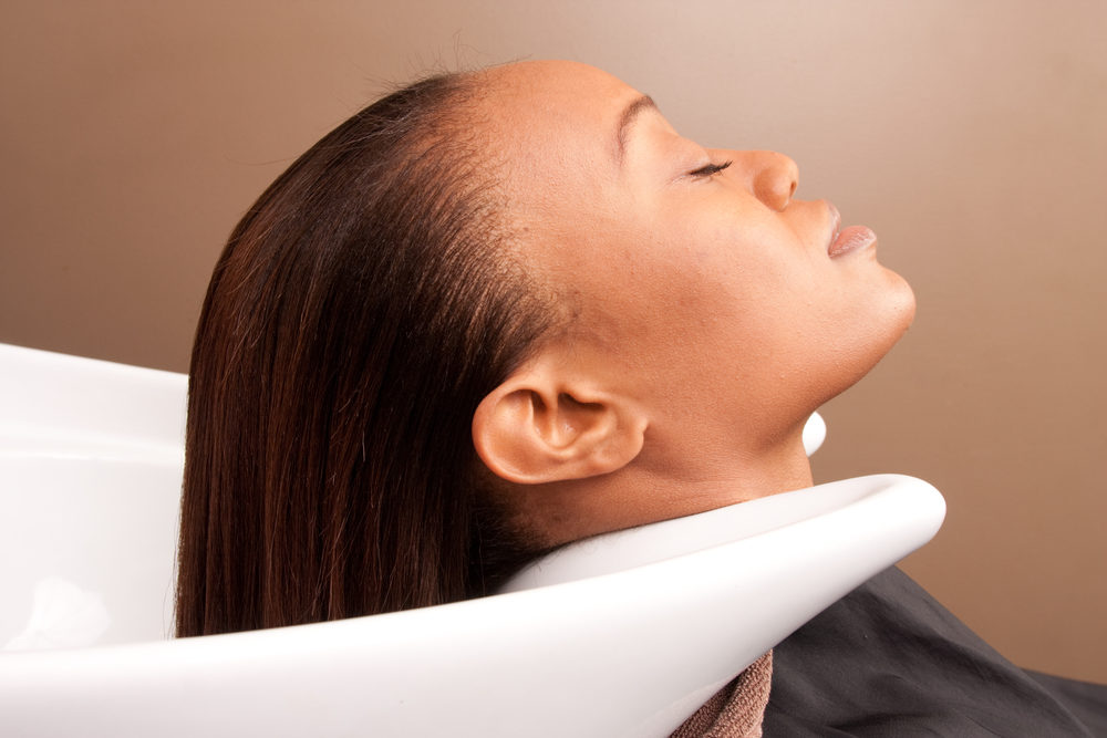 woman with her hair in a sink after straightening