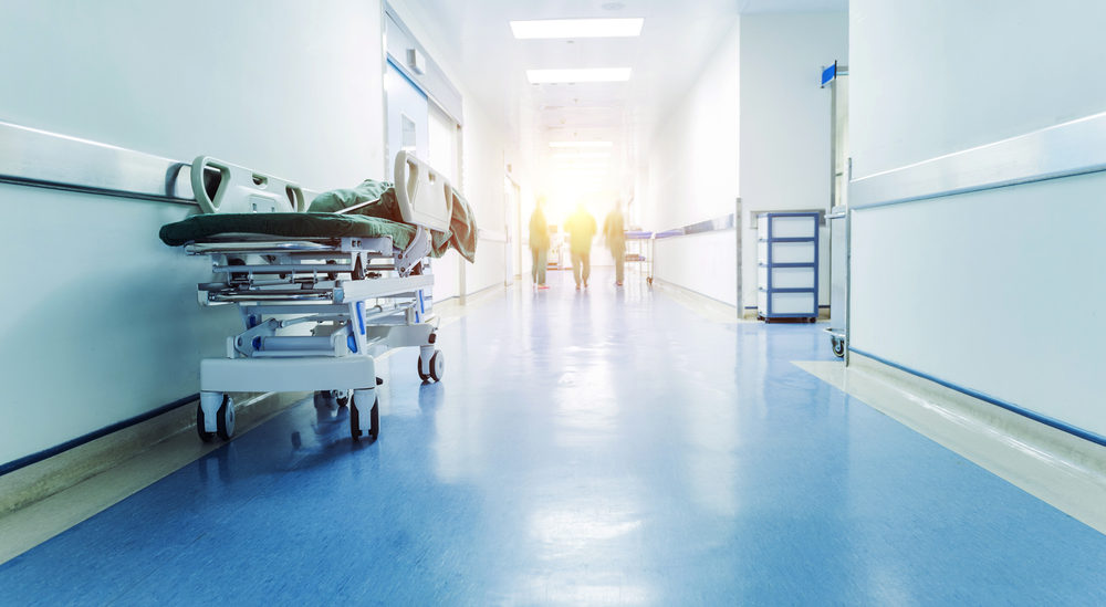 Doctors and nurses walking in hospital hallway, blurred motion.