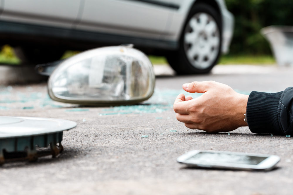Widow of Man Killed by Drunken Lamborghini Driver Now Being Sued by Insurance Company Close-up of hand of a careless driver involved in an incident after using a phone while driving