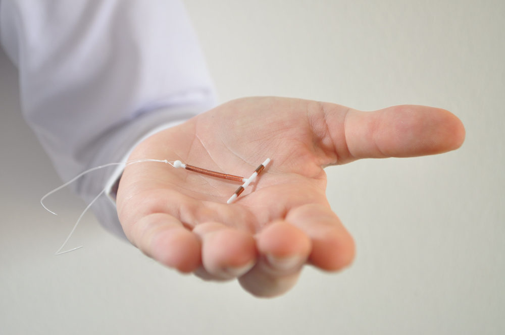 Holding an IUD birth control copper coil device in hand