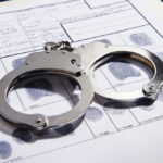 Handcuffs on top of a set of fingerprints file