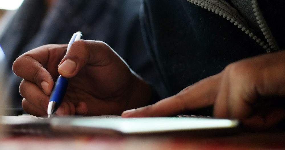 Man Signing some papers with a blue pen