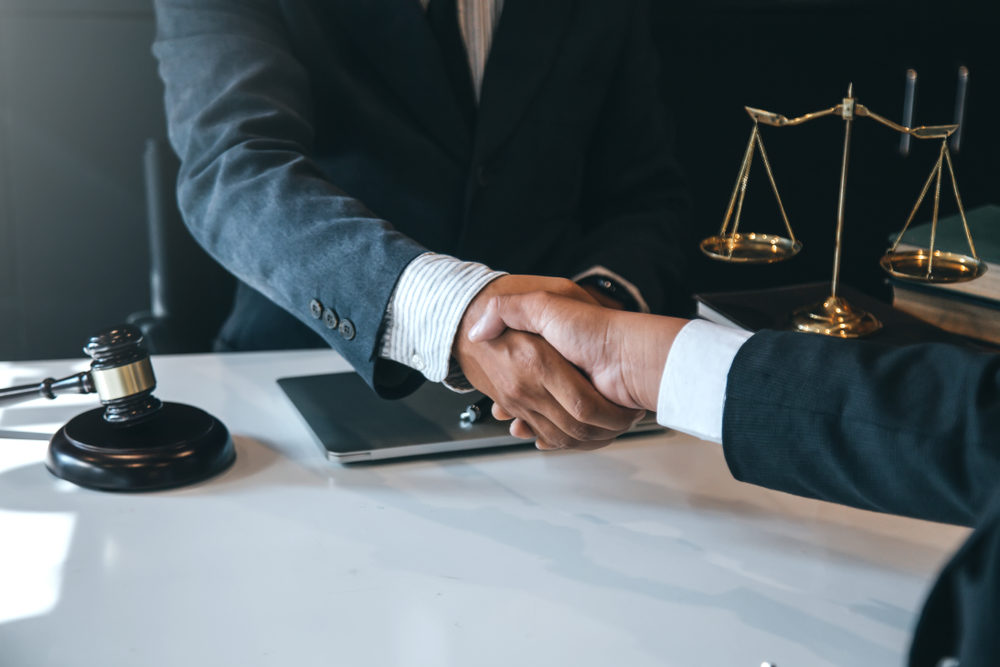 What To Expect From A Detroit Personal Injury Attorney Businessman shaking hands to seal a deal with his partner lawyers or attorneys discussing a contract agreement.