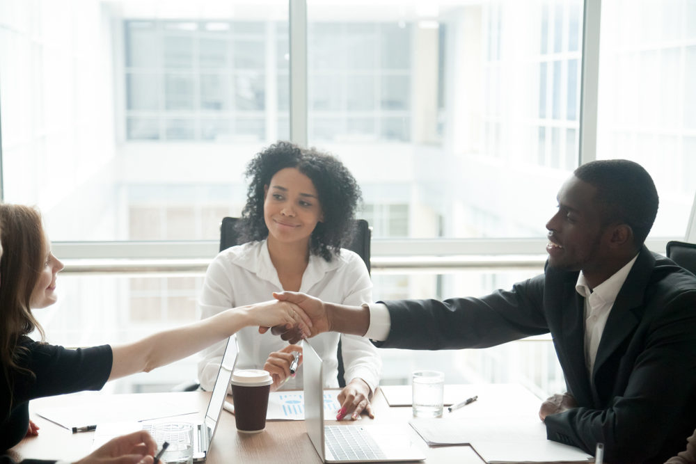 people shaking hands at desk with a mediator
