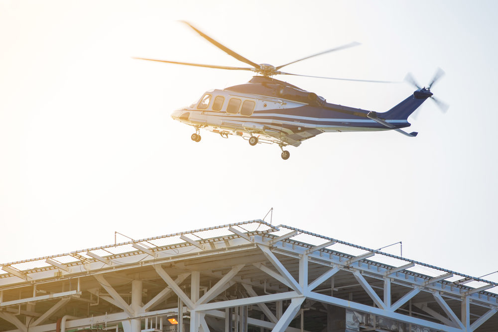 Helicopter transferring oil rig worker between shore and offshore