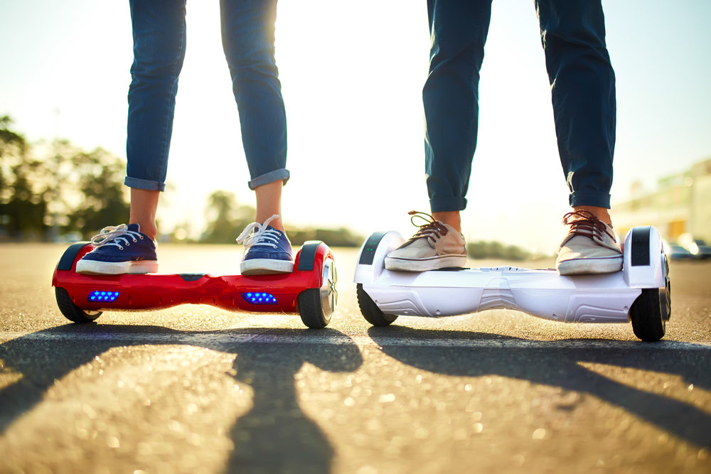 Two hoverboards, red and white, being ridden side-by-side