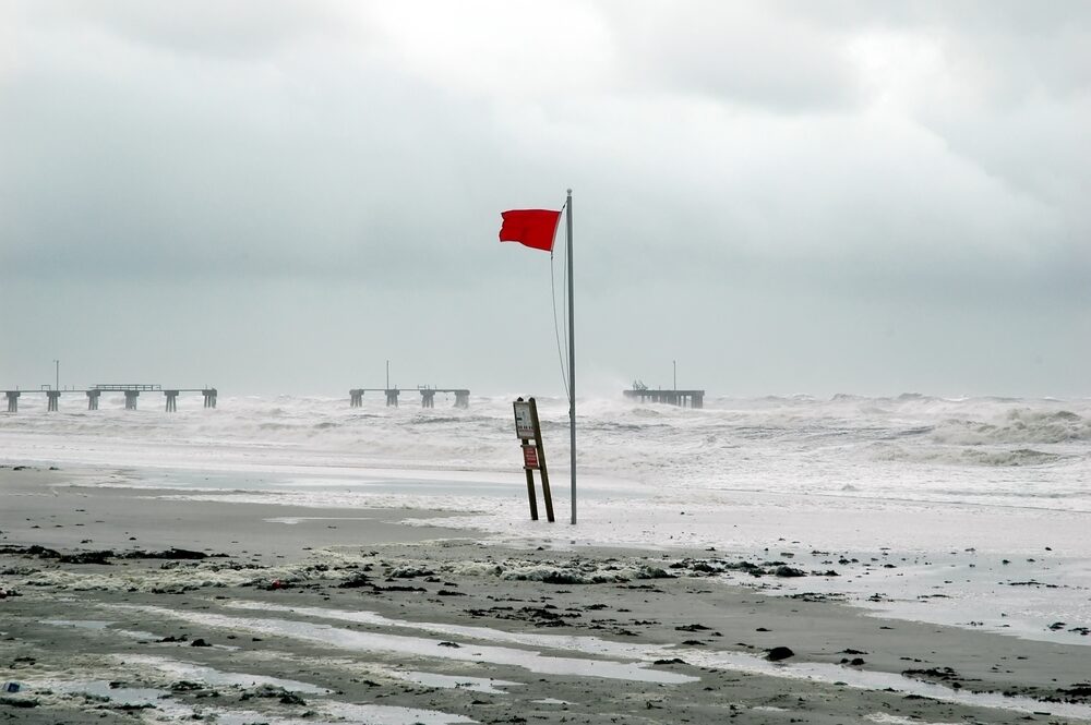 What Does a Near-Normal Hurricane Season Mean for Louisiana? red flag flying at beach warning of oncoming hurricane