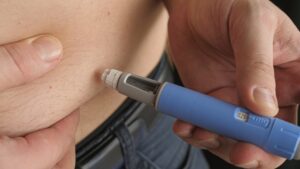 man injecting semaglutide (ozempic, wegovy) into his belly