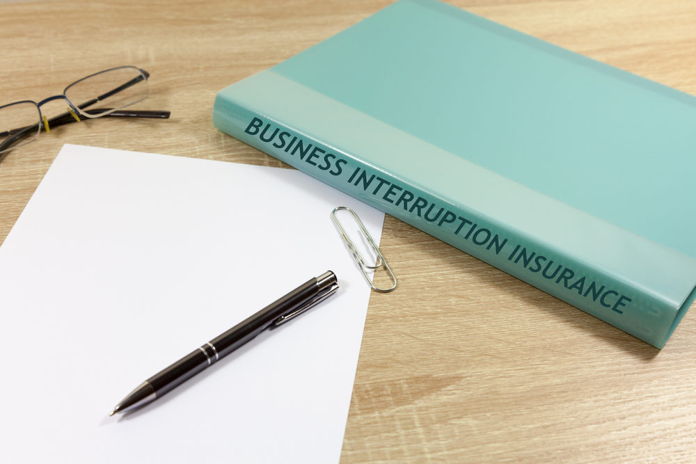 Folder and paper on desk - folder reads 'Business Interruption Insurance'
