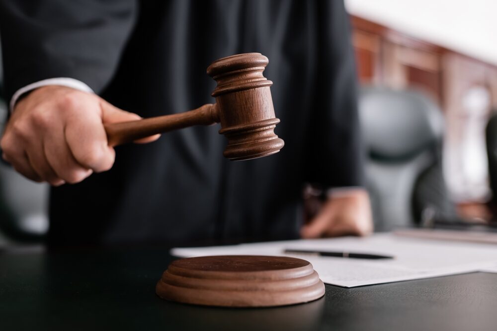 closeup of a male judge holding a gavel in a courtroom