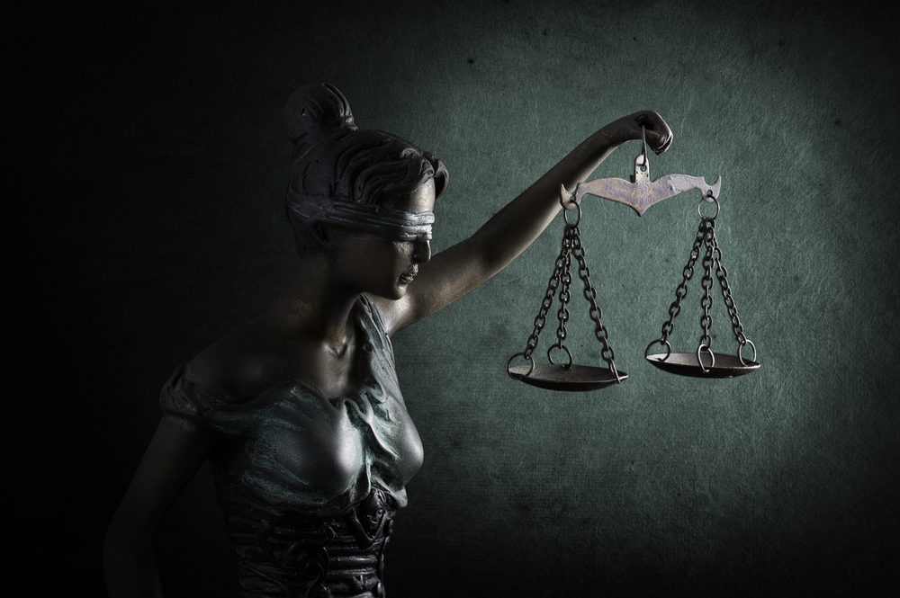 Former US speed skater announces partnership to benefit survivors of child sexual abuse Lady Justice or Themis or Justilia (Goddess of justice) on emerald background
