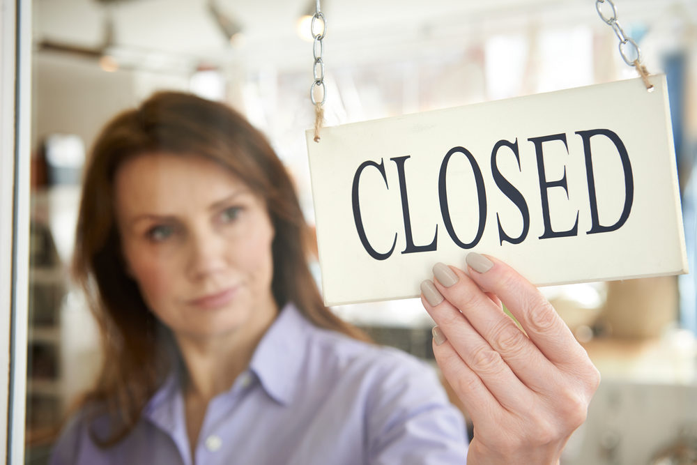 Shutdown Boredom? Do Some Good! Woman Store Owner Turning Closed Sign In Shop Doorway