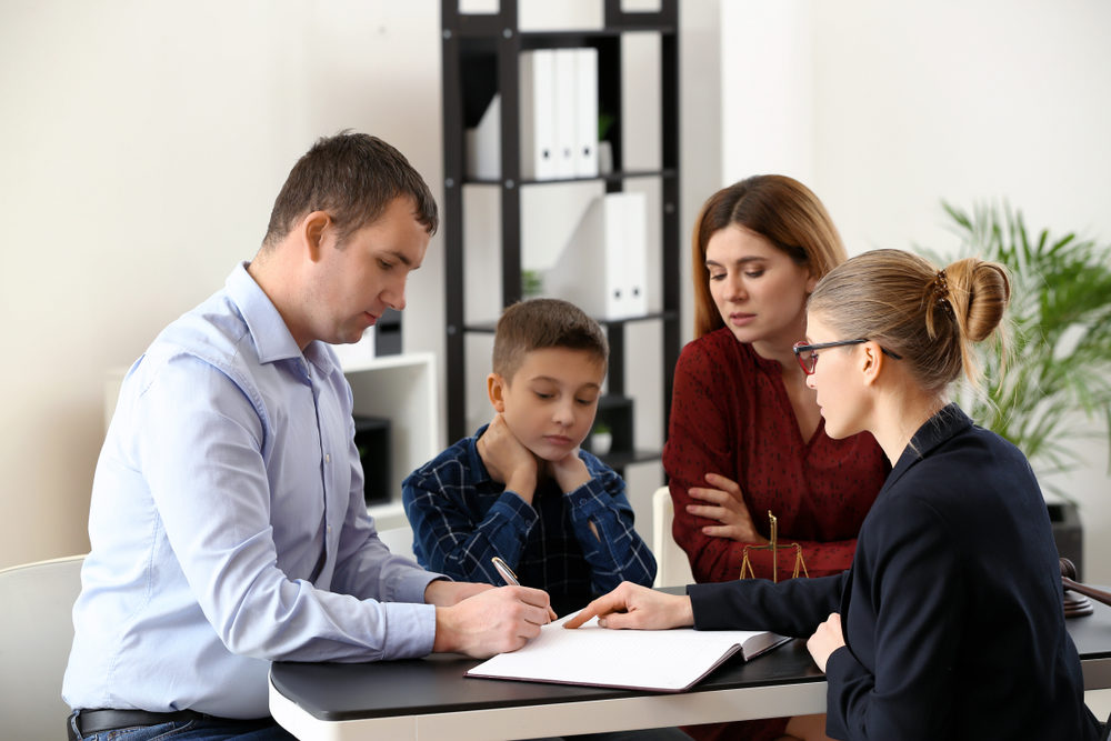 Divorced parents with their son visiting lawyer.