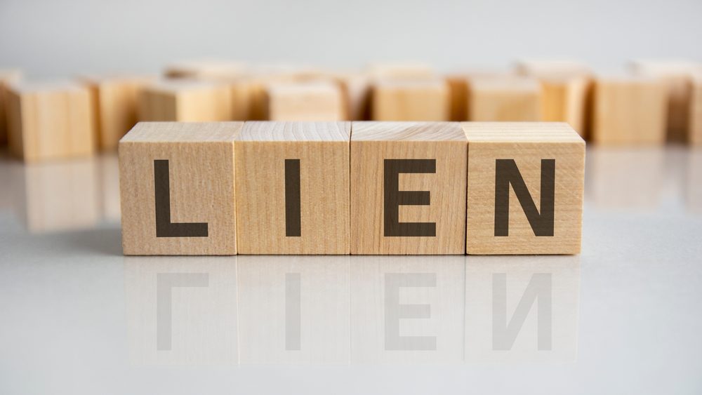 lien text on a wooden blocks, gray background