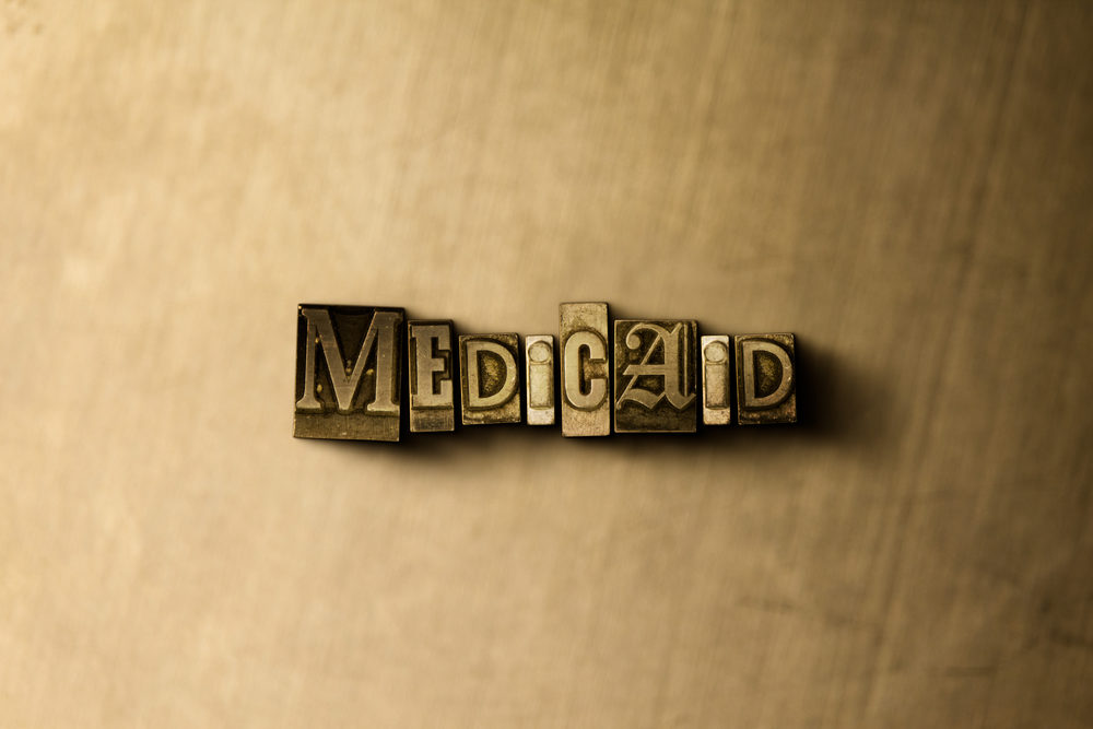Medicaid Lien Resolution Fundamentals MEDICAID - close-up of grungy vintage typeset word on metal backdrop.