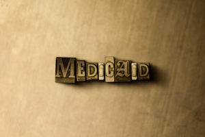 MEDICAID - close-up of grungy vintage typeset word on metal backdrop.