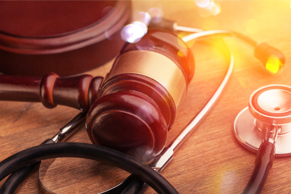 Gavel and stethoscope on wooden background, symbol photo for bungling and medical error