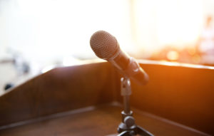 microphone on a podium with blurred conference room in background
